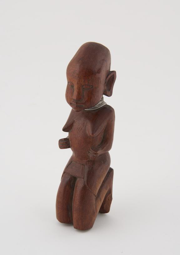 Carved wooden figure of a female, flat forehead, small arms