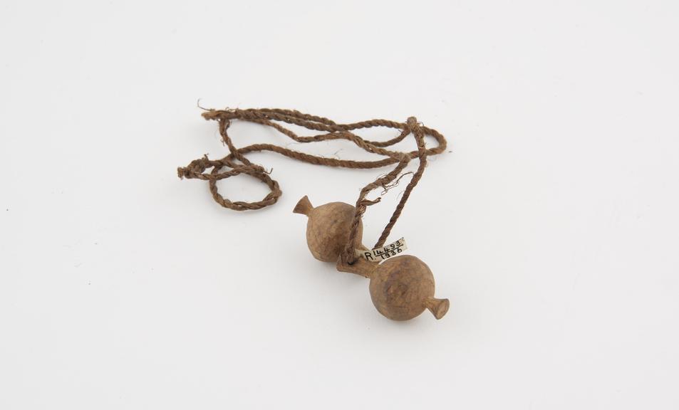 Amuletic necklace of two carved wooden spherical amulets