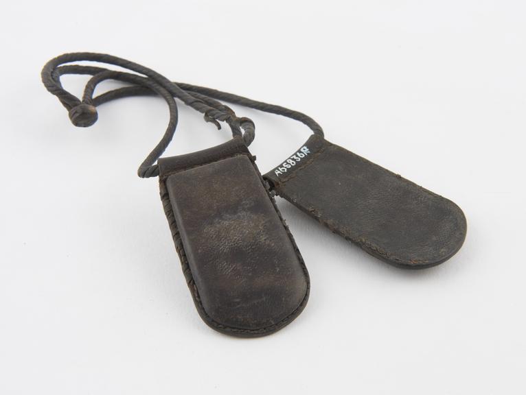 Two stitched leather amulet cases suspended from twisted