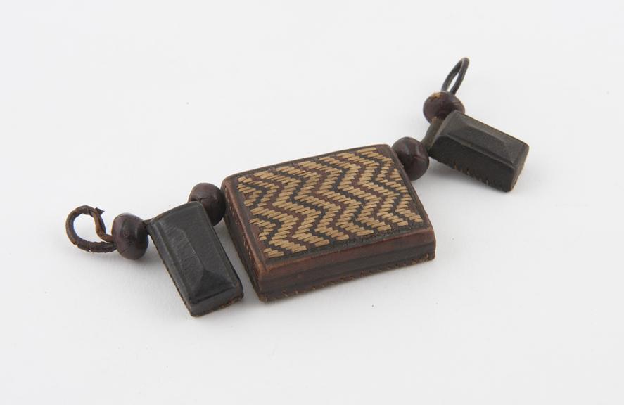 Looped thong threaded with three leather amuletic cases