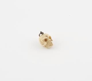 Amuletic model of human skull for suspension