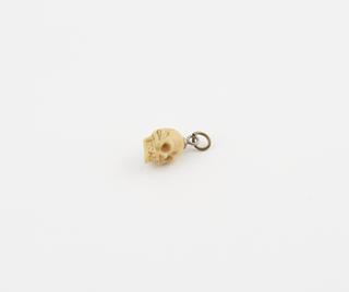 Amuletic miniature human skull for suspension