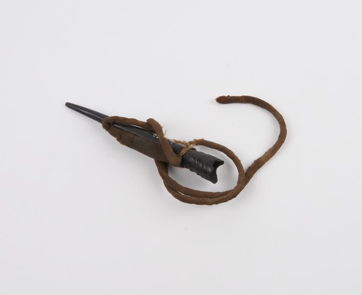 Animal horn amulet tied to a stitched cloth necklace