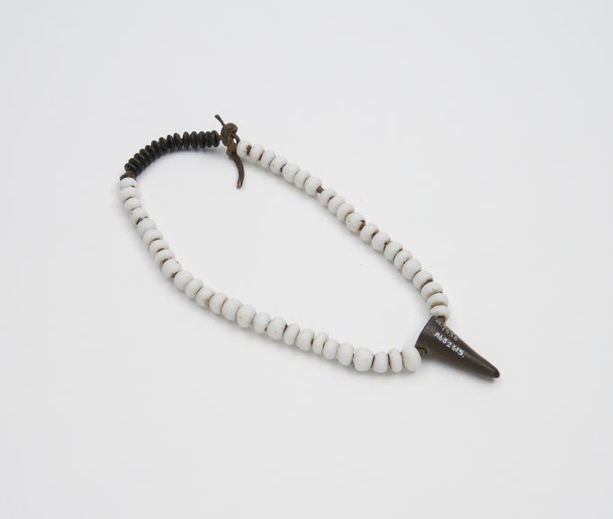 White bead necklace with horn tip in centre sold by medicine