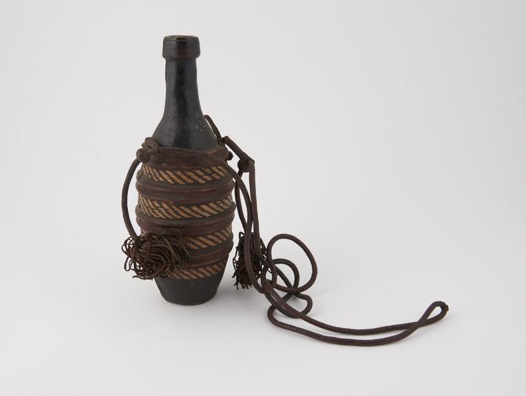 Water bottle, glass, with cover of leather and straw