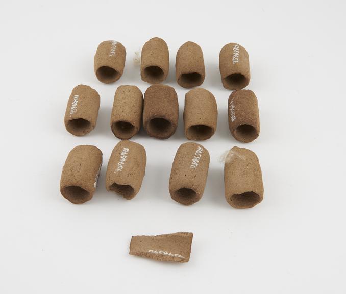 Thirteen clay curlers, hollow cylinders