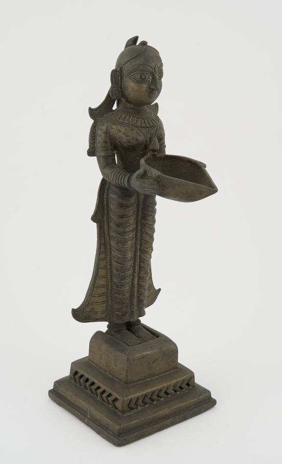 Brass statue of Lakshmi holding a bowl, used as an oil lamp