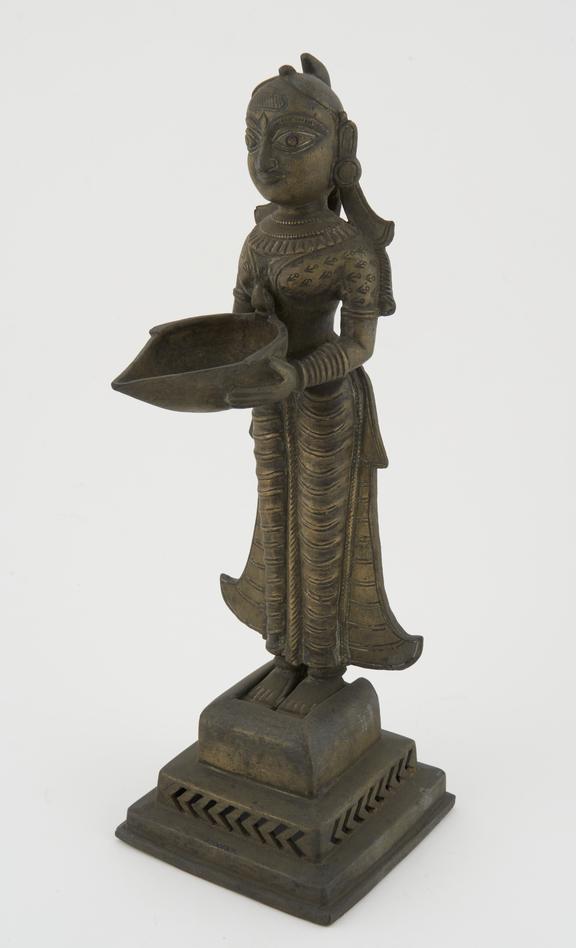 Brass statue of Lakshmi holding a bowl, used as an oil lamp