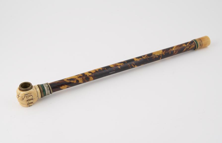 tortoiseshell tobacco pipe in form of fist holding a brass bowl