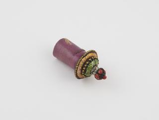 Earplug of rolled purple palm-leaf with polychrome two-tiered decorative end