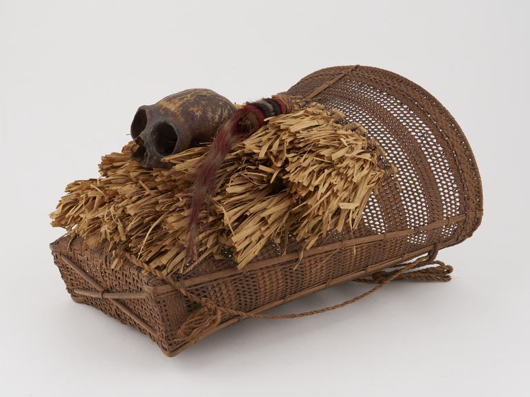 Head hunter's basket decorated with raffia fringing