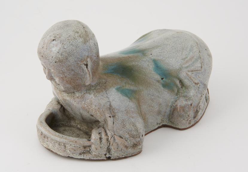 Pottery pillow, in the form of a kneeling boy, Chinese