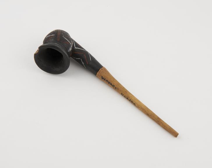 Black pottery tobacco pipe decorated with incised lines inlaid