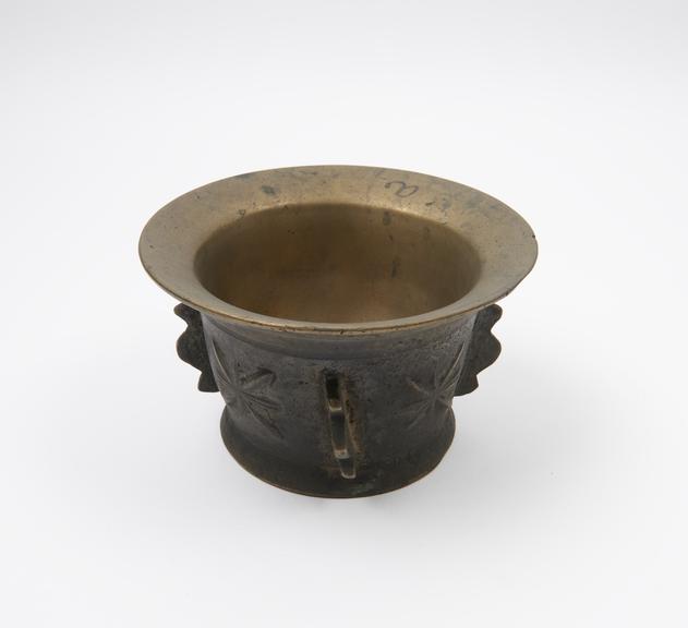 Small squat bronze mortar, wide everted rim, high flaring foot