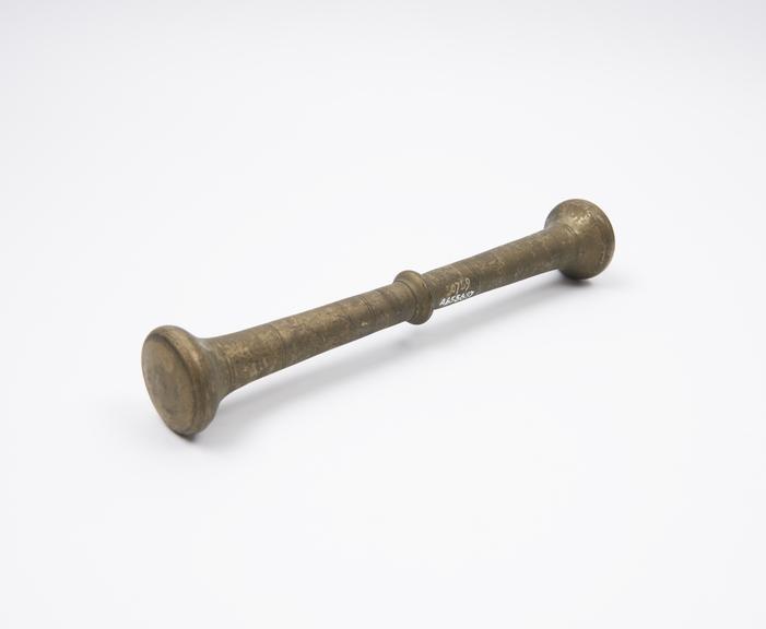 Double-ended brass pestle tapering to central flange, European