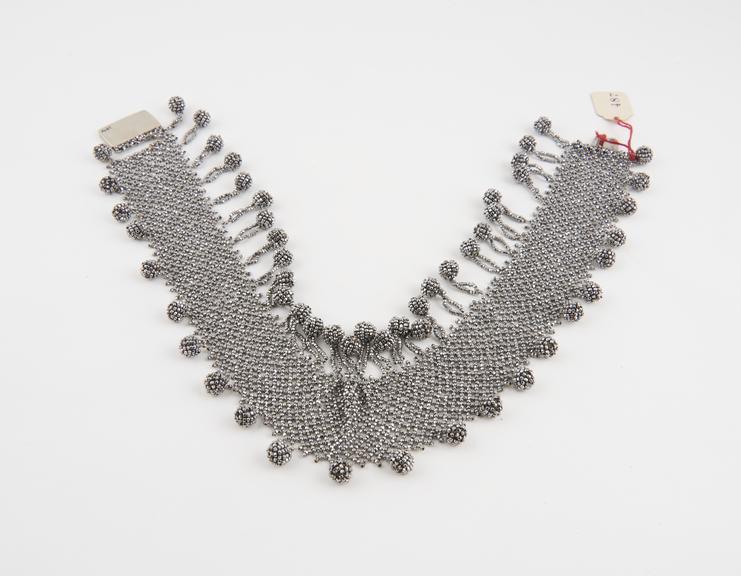 Necklace of cut steel studs consisting of netting, ball fringed