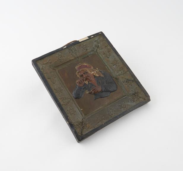 Pottery plaque moulded in one piece showing bust of old woman