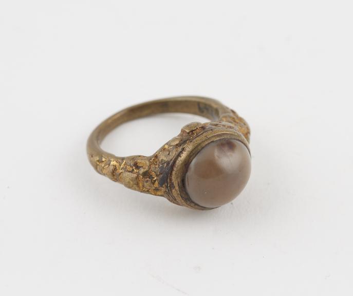 Metal finger ring, set with globular brown stone