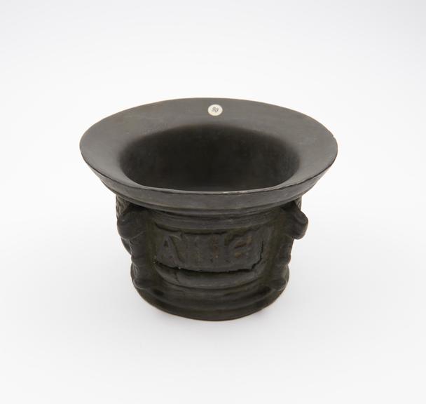 Squat bronze mortar, flat base, convex body, flaring rim