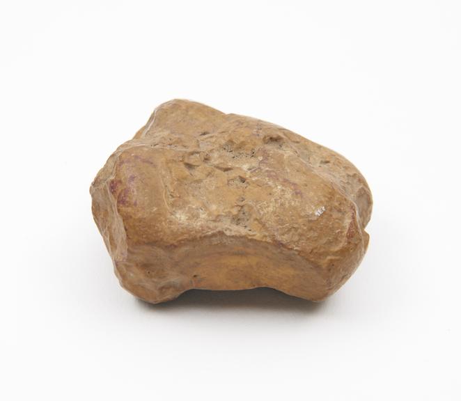 Irregularly shaped piece of orange-brown stone