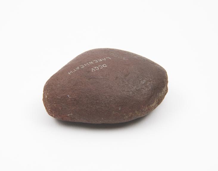 Solid dark red stone, pear-shaped and flattish, used as pounder