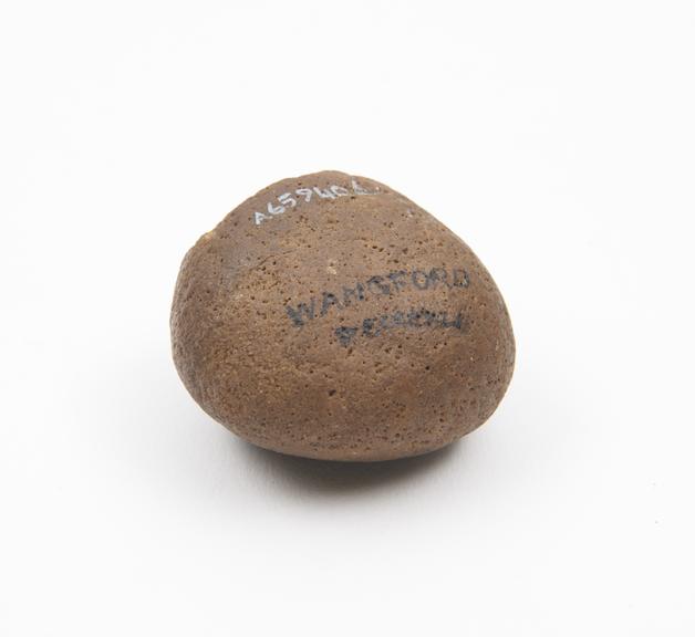 Rounded stone with flattened pounding surface, brown