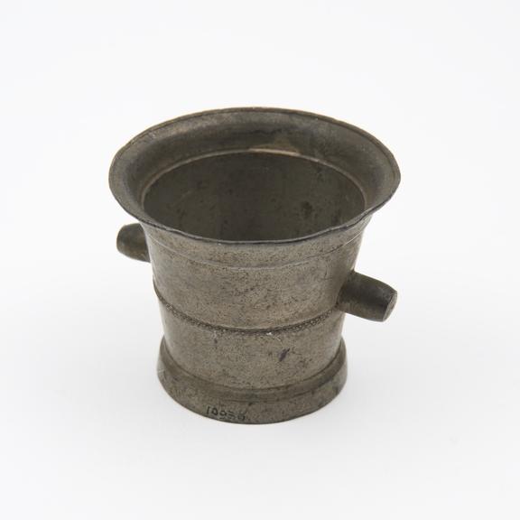 Small tin mortar with small raised pattern around waist