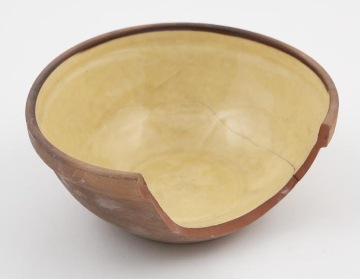 Small bowl of red earthenware, broken to show texture