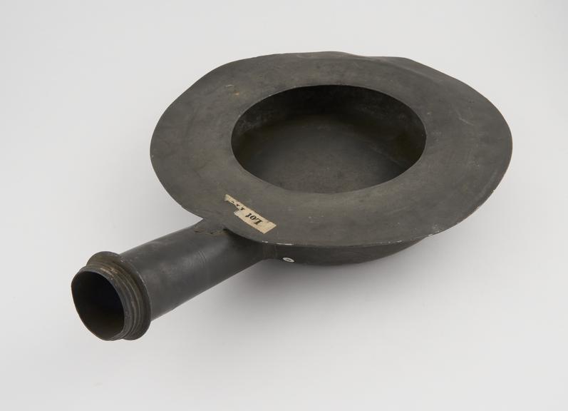 Pewter bedpan, circular, with wide flat rim and straight handle