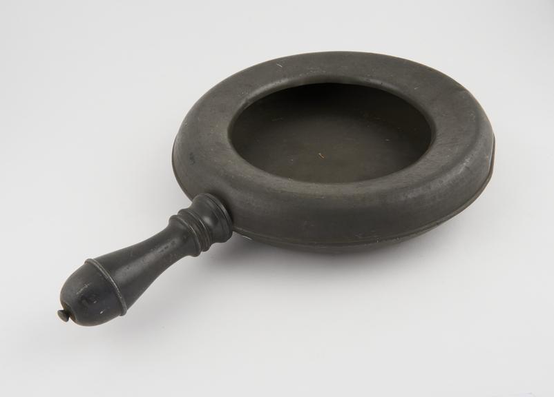 Circular pewter bedpan with flattened rounded rim and screw on