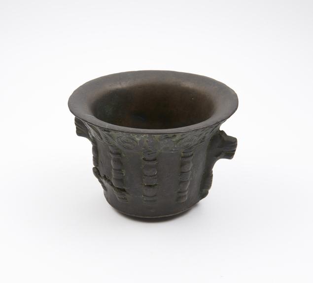 Squat bronze mortar with concave body and flaring rim