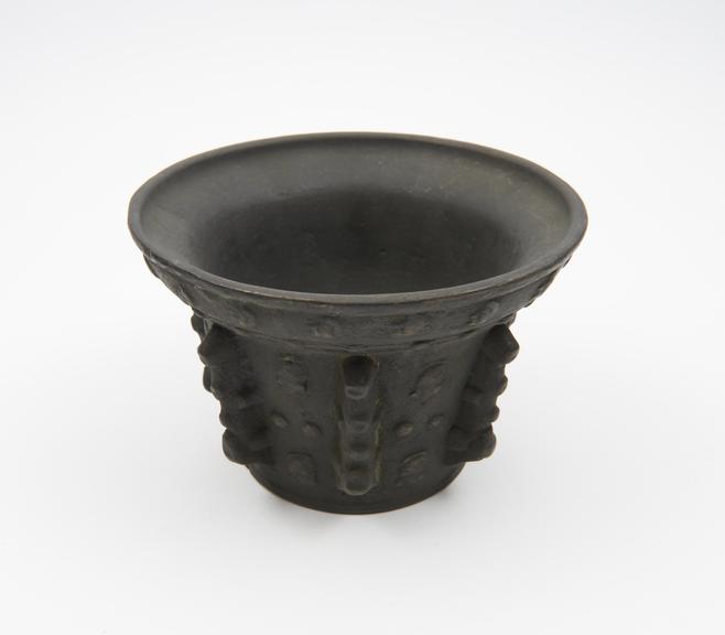 Small bronze mortar, flared rim, flat base, 7 knobly ribs