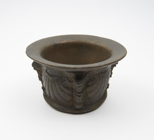 Small squat bronze mortar, wide flared rim and projecting foot