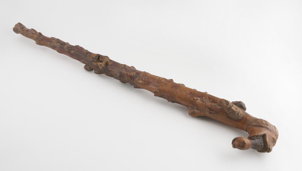 Heavy staff, made of gnarled wood with carved heads and handle