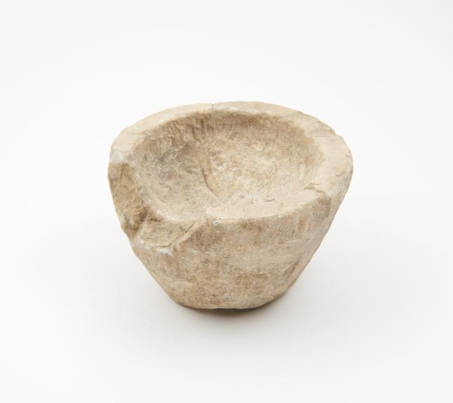 Small bucket-shaped mortar, roughly carved from white stone