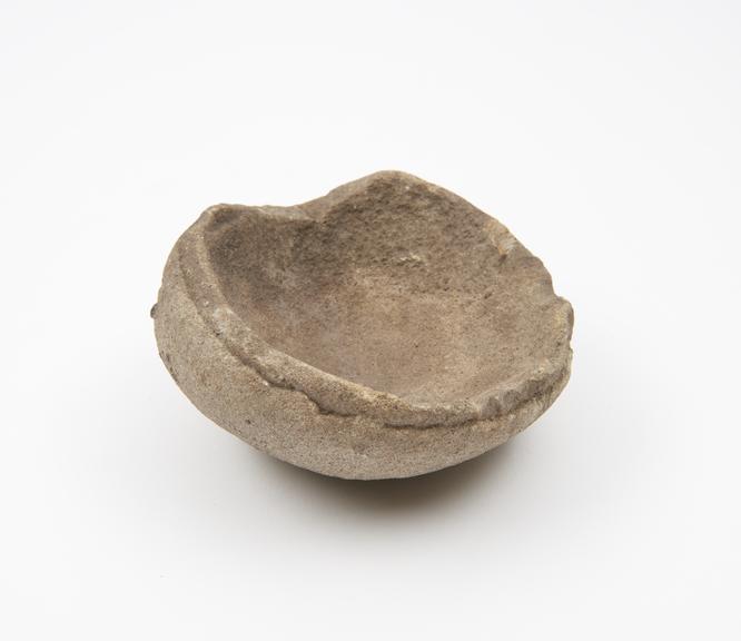 Dish-like stone mortar with asymmetrical rounded base