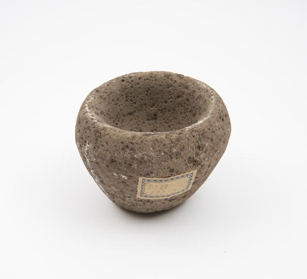 Small uneven mortar in large grained stone containing grits
