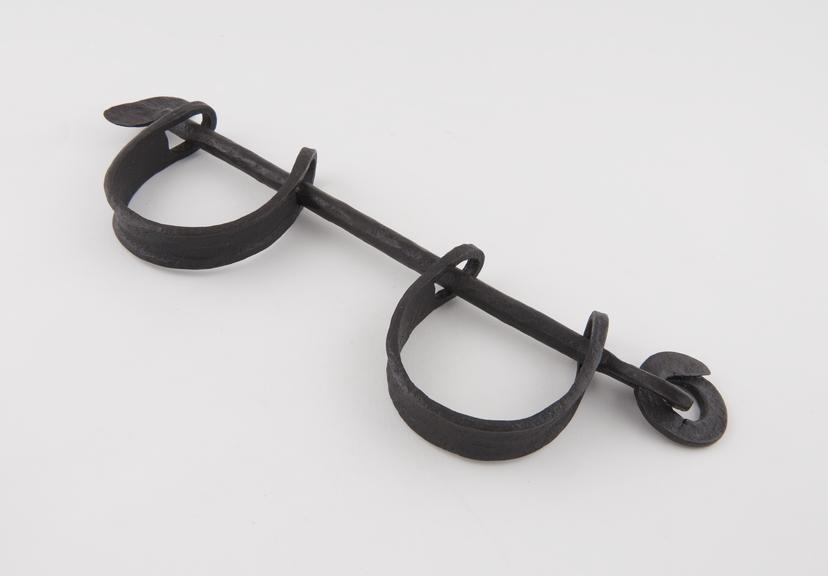 Pair of leg irons linked by iron rod