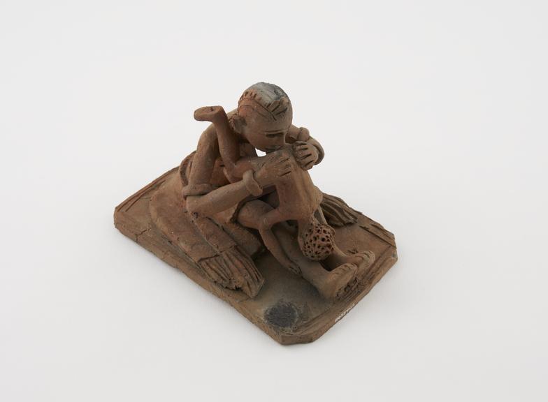 Terra cotta model depicting a mother administering an enema to her child