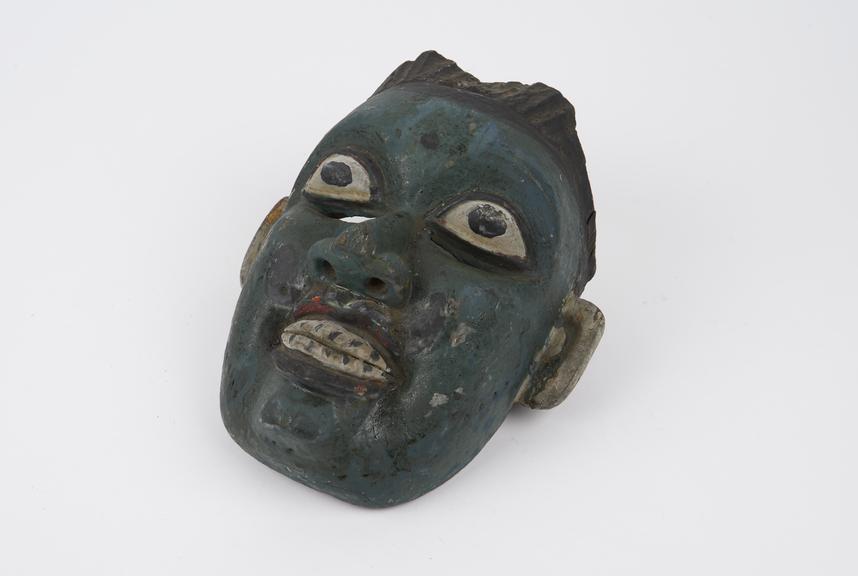 Carved painted wooden mask of full-faced young man