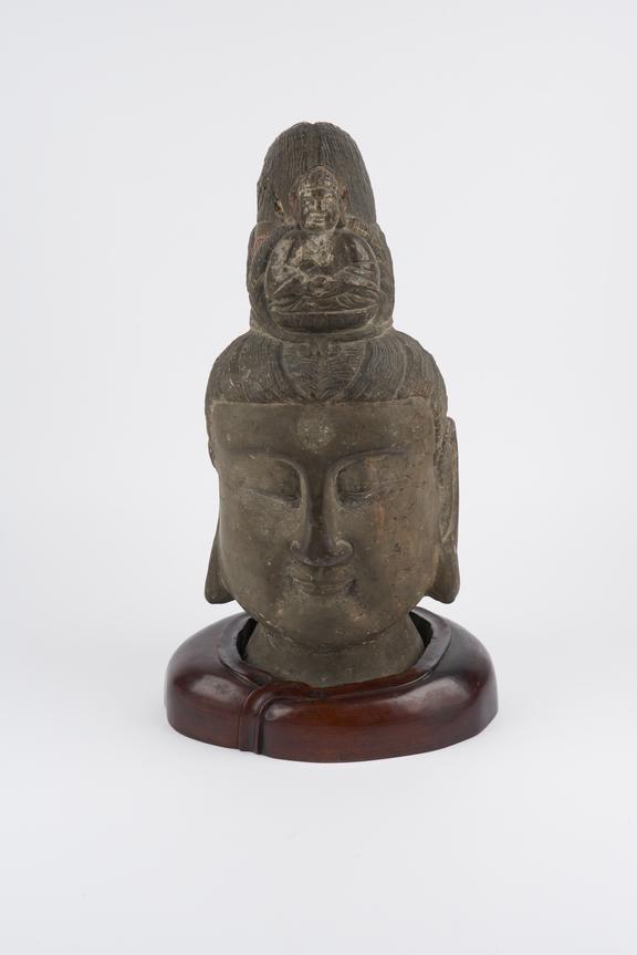 Head of Kuan-Yin surmounted by buddha, stone on wooden base