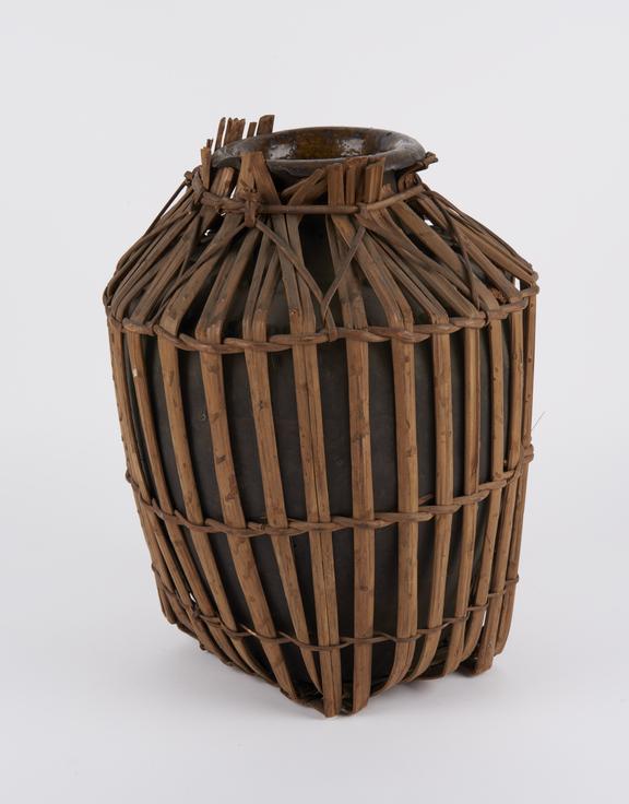 Brown stoneware jar, fitted with cane jacket and carrying handle