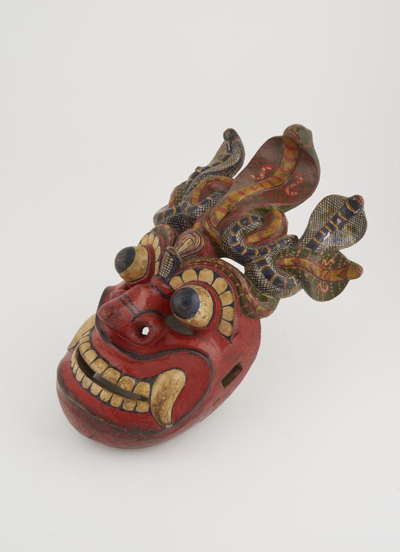 Wooden mask, polychrome, with sockets for missing ear-pieces