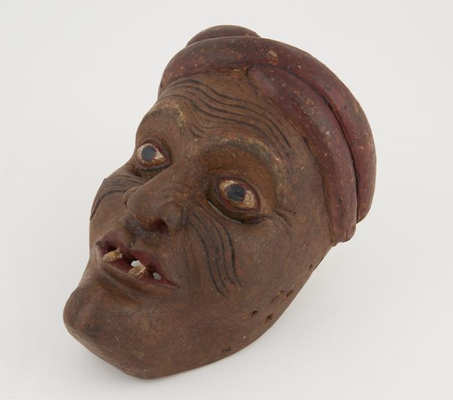 Carved and painted wooden mask representing brown-faced