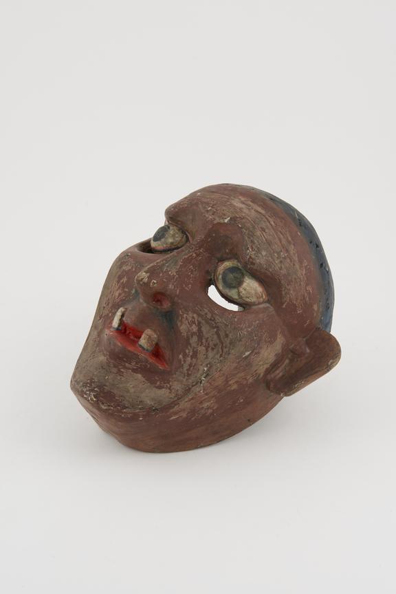 Carved and painted wooden face mask representing brown-faced