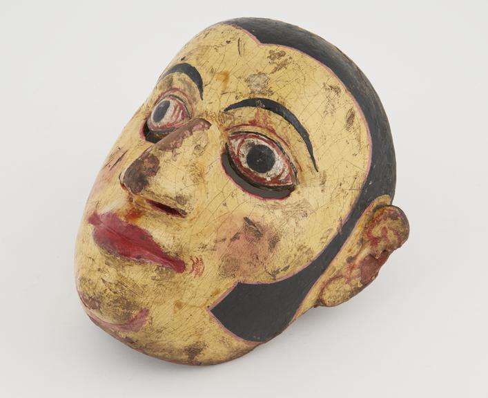 Painted wooden face mask, yellow with polychrome detail