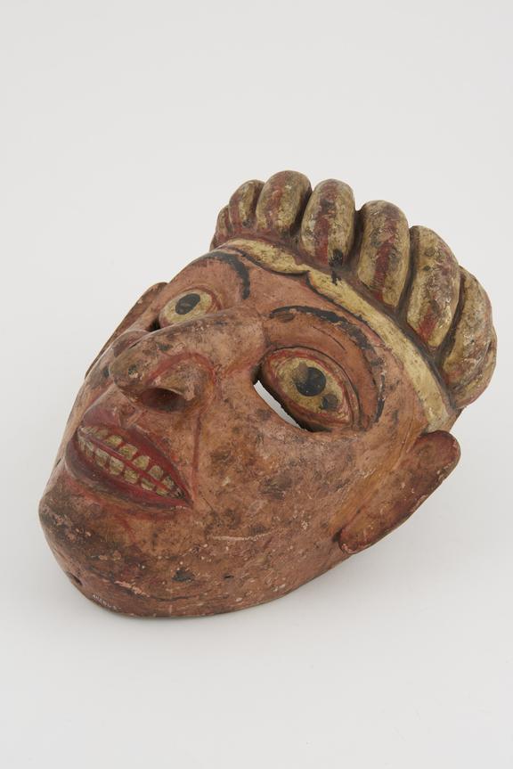 Carved and painted wooden mask representing pink faced young