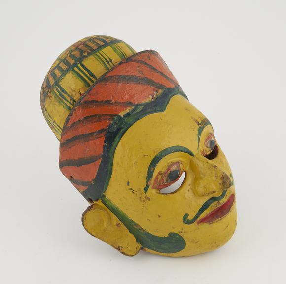 Painted wooden face mask, yellow with polychrome detail