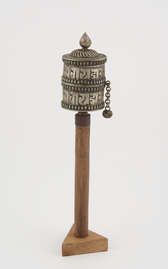 Metal prayer wheel on wooden mount attached to handle, Tibetan