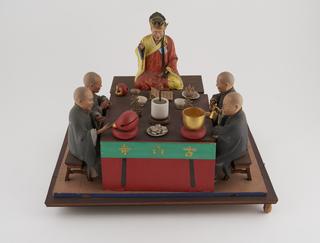 Group of painted wooden figures on a rectangular base